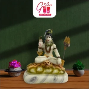 Lord Shiva marble idol with trishul and damru, placed on a wooden surface with small decorative plants, from Gift My Way